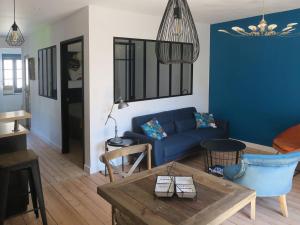 a living room with a blue couch and a table at L'atelier d'artiste charmant T2 centre historique in Dinan +2 photos