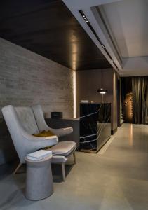 een woonkamer met een stoel en een tafel bij Niki Athens Hotel in Athene