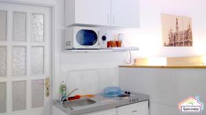 a kitchen with a sink and a microwave at Szín-Ház Apartman in Gyula