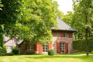 een klein bakstenen huis met een rode deur bij Schloss Wissen in Weeze