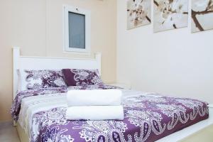 una camera con letto viola e bianco con cuscini di Apartments4you Bally a Bat Yam