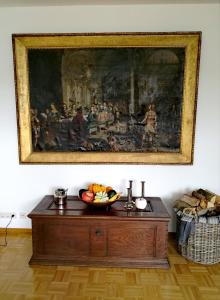 una pintura en una pared con un bol de fruta en una mesa en LUXURIÖSE FERIENWOHNUNG CONFLUENTIA IN DER KOBLENZER ALTSTADT, en Coblenza