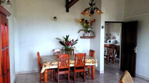a dining room with a table with chairs and flowers on it at Villa Welcome in Trois-Rivières