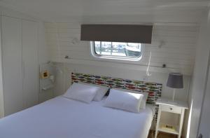 a bedroom with a white bed and a window at Tagus Marina in Lisbon