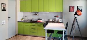 a kitchen with green cabinets and a white table at Athens Suites in Athens