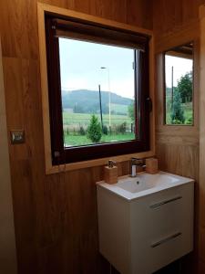 a bathroom with a sink and a window at Domki całoroczne z kominkiem - SKAŁA i GŁAZ in Szczytna