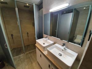 a bathroom with a sink and a shower and a mirror at Bed Station 210 in Kandy