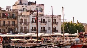 um grupo de barcos ancorados em frente a um edifício em Kyrenia British Harbour Hotel em Cirénia