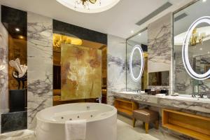 a bathroom with a tub and a large mirror at Wyndham Shanghai Nanxiang in Jiading
