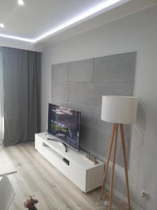 uma sala de estar com televisão num armário branco em Apartament Nowa Letnica em Gdansk