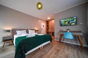 a bedroom with a bed and a desk and a tv at PARK45 in Sopot