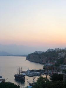 a group of boats in the water at sunset at Mavi Avlu - Old town apartments in Antalya