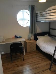 a bedroom with a bed and a desk and a bunk bed at 5 Shell Hill Mews in Coleraine