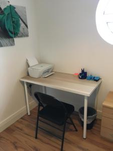 a desk with a printer and a chair in a room at 5 Shell Hill Mews in Coleraine
