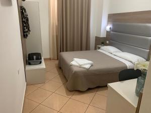 Hotel Siro في ميلانو: غرفة فندقية بسرير وغرفة صغيرة