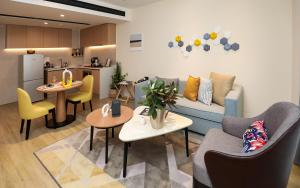 a living room with a couch and tables and a kitchen at Citadines Gaoke Liangjiang Chongqing in Chongqing