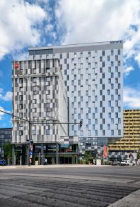 ein hohes weißes Gebäude mit einer Straße davor in der Unterkunft Novotel Wien Hauptbahnhof in Wien