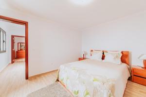 a white bedroom with a bed and a mirror at Casa da Morena by Amazing Madeira in Santa Cruz +26 photos