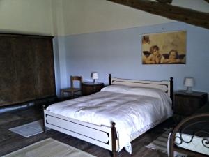 1 dormitorio con 1 cama y una pintura en la pared en Agriturismo Valpagliaro, en Formignana
