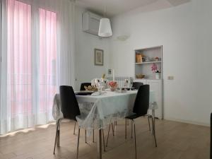 una sala da pranzo bianca con tavolo e sedie di Temporary House vicolo Colombina a Bologna