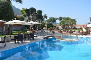 un resort con piscina, tavoli e ombrelloni di Villa Dei Fiori a Montoro Inferiore