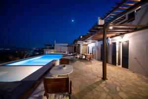 eine Villa mit einem Pool in der Nacht in der Unterkunft Siourdas Mykonos Villas in Agios Sostis Mykonos