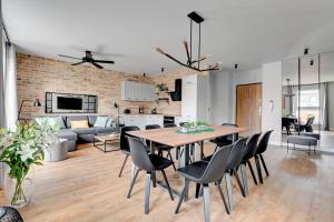 a dining room and living room with a table and chairs at Staywin Apartments in Gdańsk