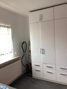 ein Zimmer mit einem großen weißen Schrank und einem Staubsauger in der Unterkunft Ferienwohnung Pfeifer 2 in Friedrichsdorf