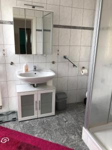 ein Bad mit einem Waschbecken und einem Spiegel in der Unterkunft Ferienwohnung Pfeifer 2 in Friedrichsdorf