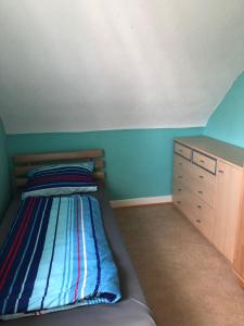 ein kleines Schlafzimmer mit einem Bett und einer Kommode in der Unterkunft Ferienwohnung Pfeifer 2 in Friedrichsdorf