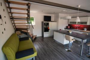 uma cozinha e sala de estar com um sofá verde e uma mesa em Ferienhaus Görmer mit Wasserbett em Schmölln