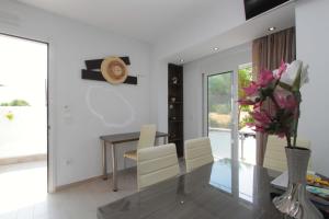 a dining room with a table and a vase of flowers at Haraki Beauty in Haraki