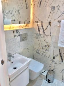 Baño blanco con lavabo y aseo en Widegate Residential en Londres