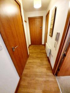 a hallway with a wooden door and a wooden floor at Southend Ground Floor Apartment with Parking in Southend-on-Sea