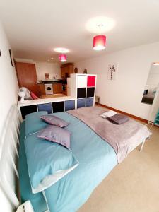 a bedroom with a bed with blue sheets and pillows at Southend Ground Floor Apartment with Parking in Southend-on-Sea