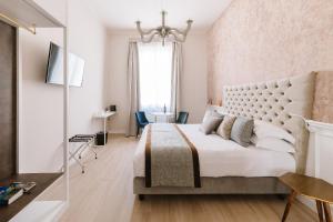 Un dormitorio con una gran cama blanca y una ventana en Rhea Silvia Luxury Navona, en Roma