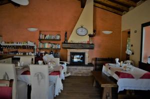 カスティリオーネ・デイ・ペーポリにあるB&B La Piazzettaのテーブル、暖炉、時計のあるレストラン
