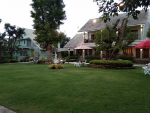 a house with a yard with chairs and tables at Scent of Sukhothai Resort in Sukhothai