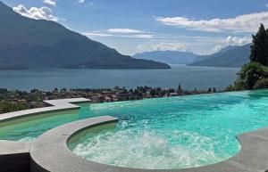 a swimming pool with a view of a lake and mountains at La Collinetta Apartments in Vercana