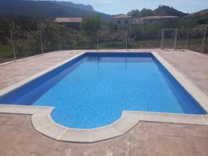 a large swimming pool with blue water in a yard at Hotel Rural Puerta de Caderechas in Terminón