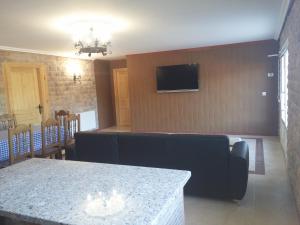 ein Wohnzimmer mit einem Sofa und einem TV an der Wand in der Unterkunft Hotel Rural Puerta de Caderechas in Terminón