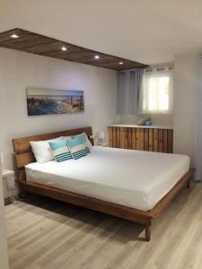 una camera da letto con un grande letto bianco con cuscini blu di Holiday Surf Lodge a Tamarin