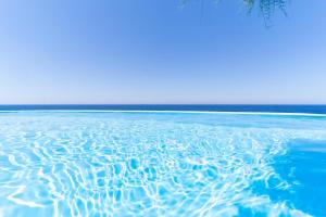 a pool of water with the ocean in the background at Ikarian Endless Blue in Kouniádhoi