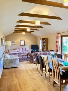 a living room with a table and a couch at Priory Farm Barn in Eye