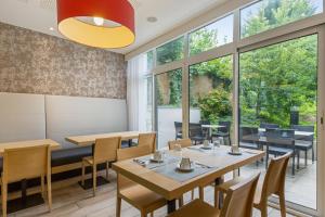 een restaurant met tafels en stoelen en grote ramen bij Résidence Pierre & Vacances La Petite Venise in Colmar +55 foto's