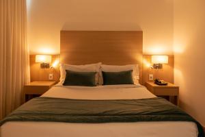 a bedroom with a large bed with two lamps at Américas Barra Hotel in Rio de Janeiro