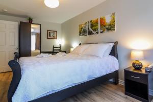 ein Schlafzimmer mit einem großen Bett und einem Tisch mit einer Lampe in der Unterkunft 2314 Rue Duff Court in Montreal