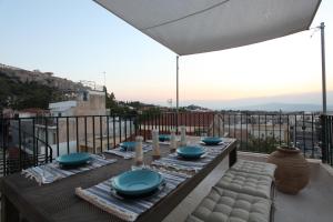 a table with blue bowls and plates on a balcony at Plaka penthouse with Acropolis views! - PL6 in Athens