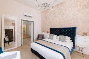 1 dormitorio con 1 cama grande y cabecero azul en Rhea Silvia Luxury Navona en Roma