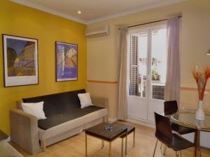 un soggiorno con divano e tavolo di Foster Apartamentos Sol a Madrid